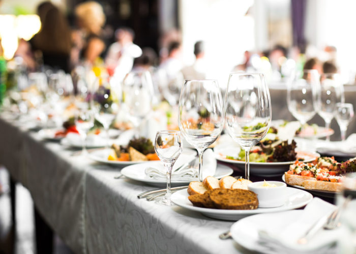 Sparkling glassware stands on long table prepared for wedding dinner